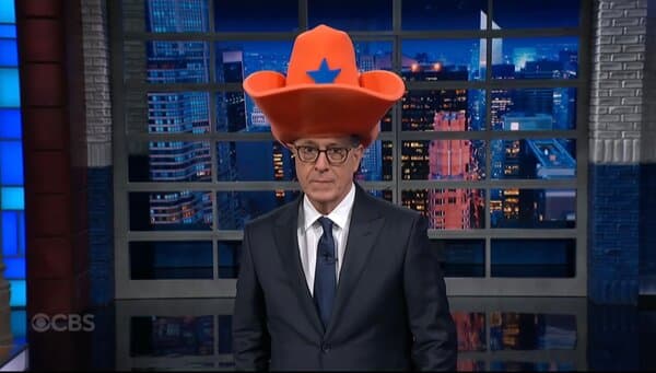 Kristi Noem wearing a large cowboy hat during a news interview