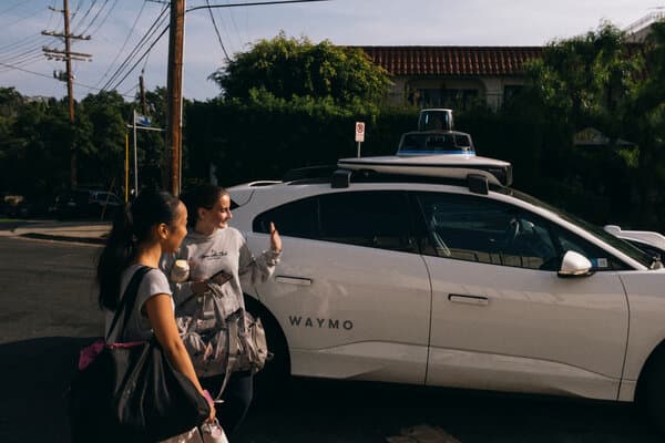 Waymo autonomous vehicle on Los Angeles street with child passenger