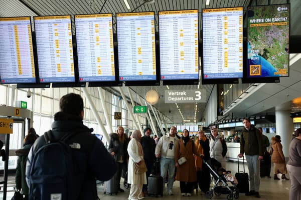 Passengers waiting at a snowy European airport terminal amid travel disruptions