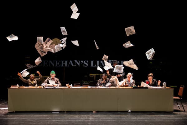 A scene from a performance at the Under the Radar Festival, showcasing actors on a minimalist stage.