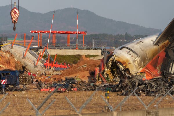 Wreckage of the Jeju Air plane near the runway wall at Muan International Airport.
