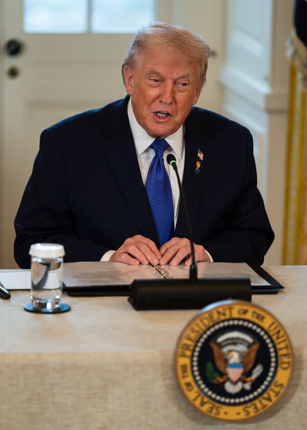 Donald Trump speaking at a podium regarding credit card interest rates